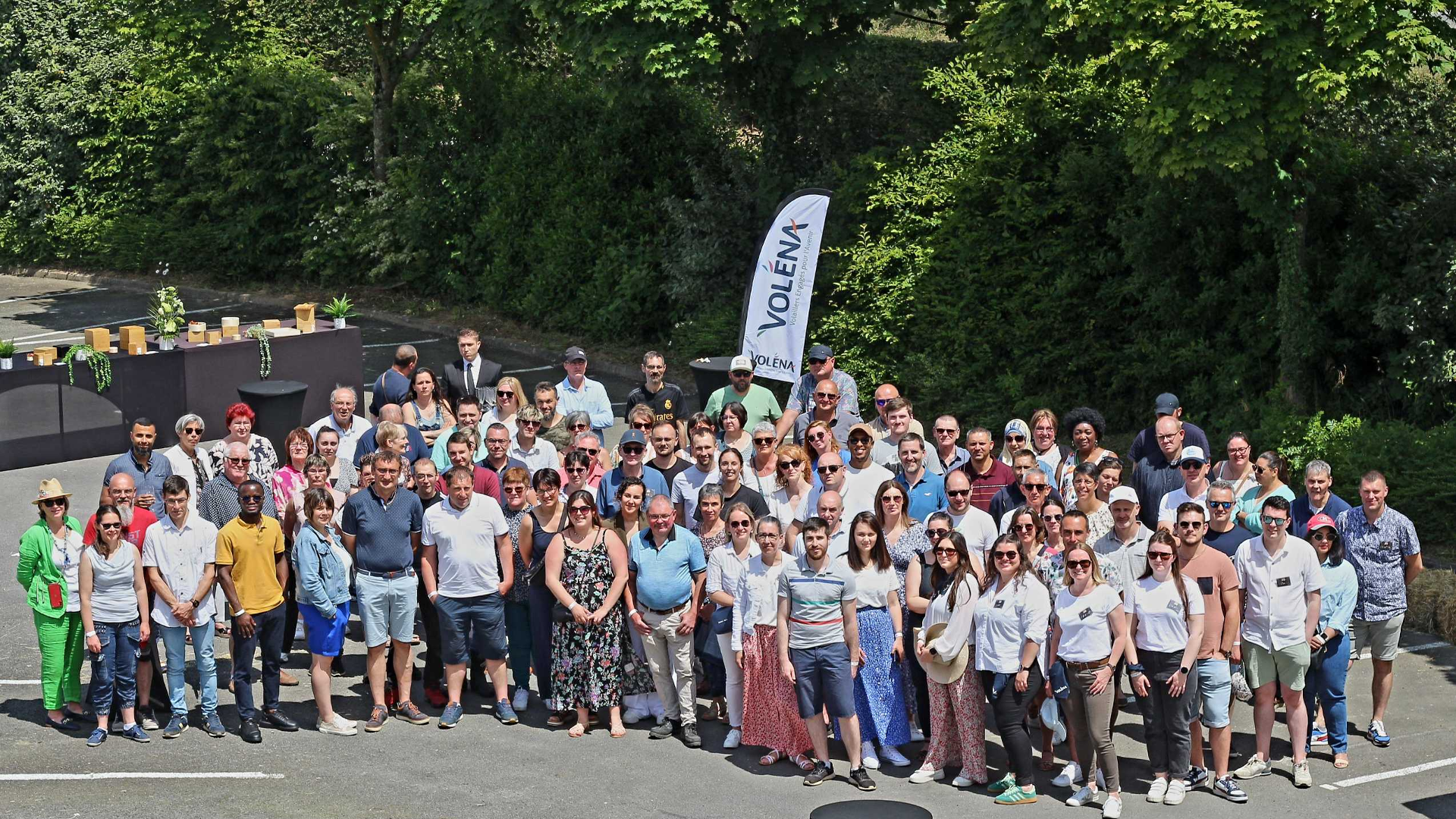 Photo de groupe des participants prise en hauteur avec le logo VOLENA en fond